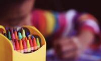 child coloring with crayons