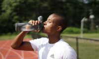 young man drinking water during the summer